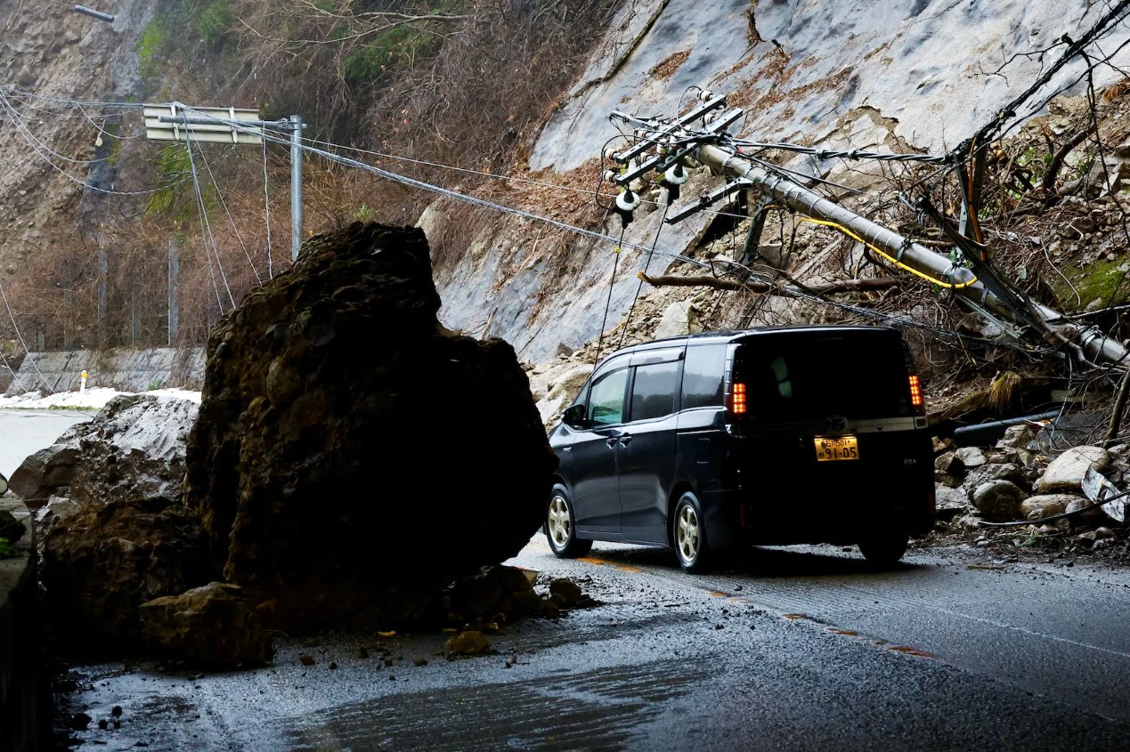 2024年1月3日，日本輪島，地震后，一輛汽車在受損的道路上行駛。