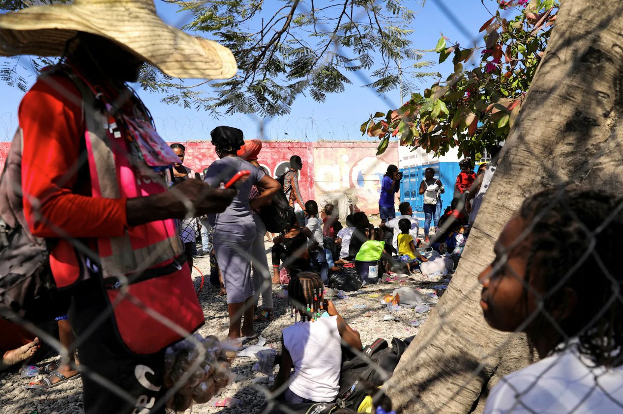 2024年2月12日，海地太子港，敵對幫派之間發生槍戰后，逃離暴力的人們抵達海地國家警察局。