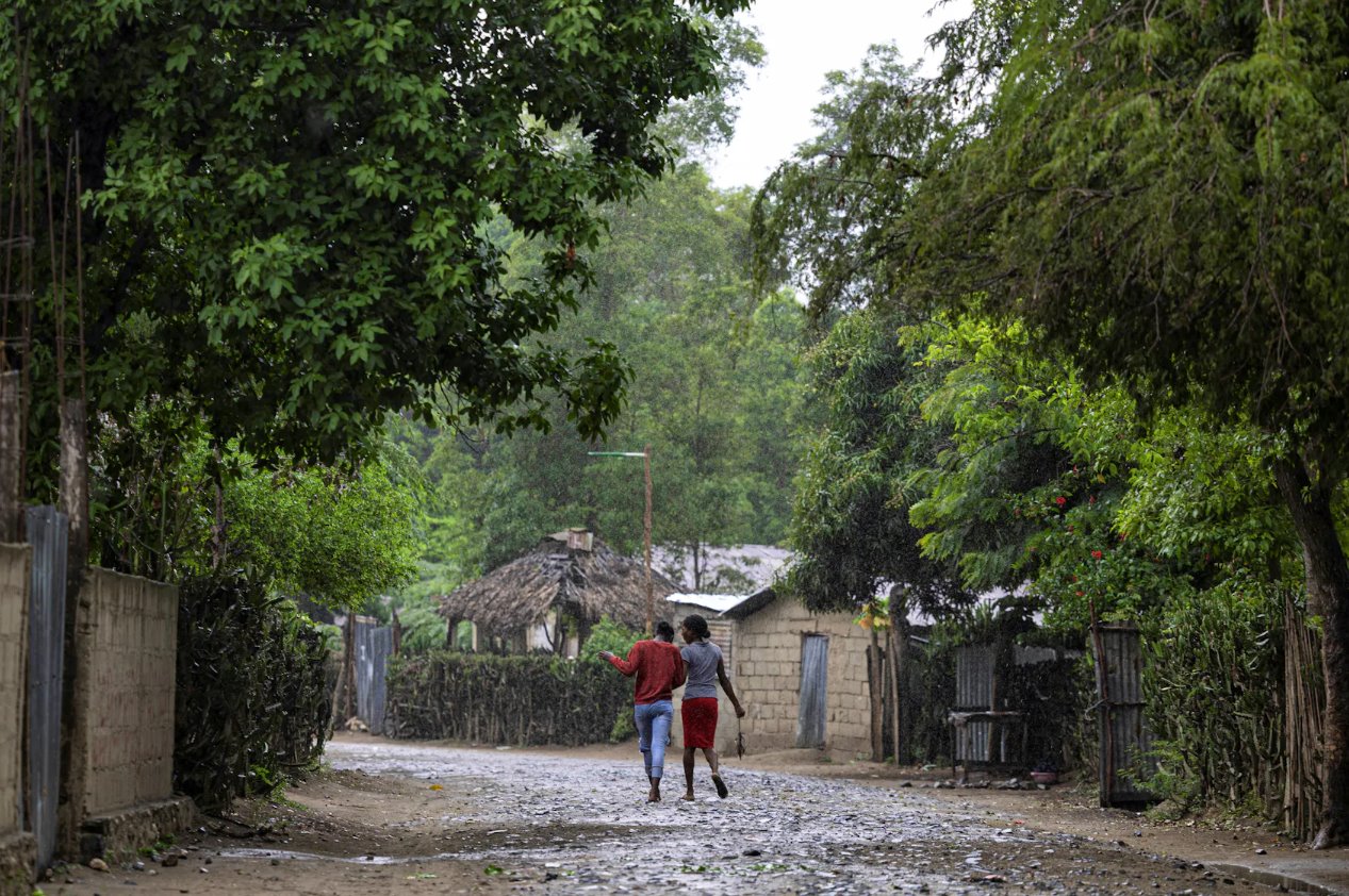 2024年4月27日,海地自由堡馬爾費蒂社區,婦女在雨中行走。