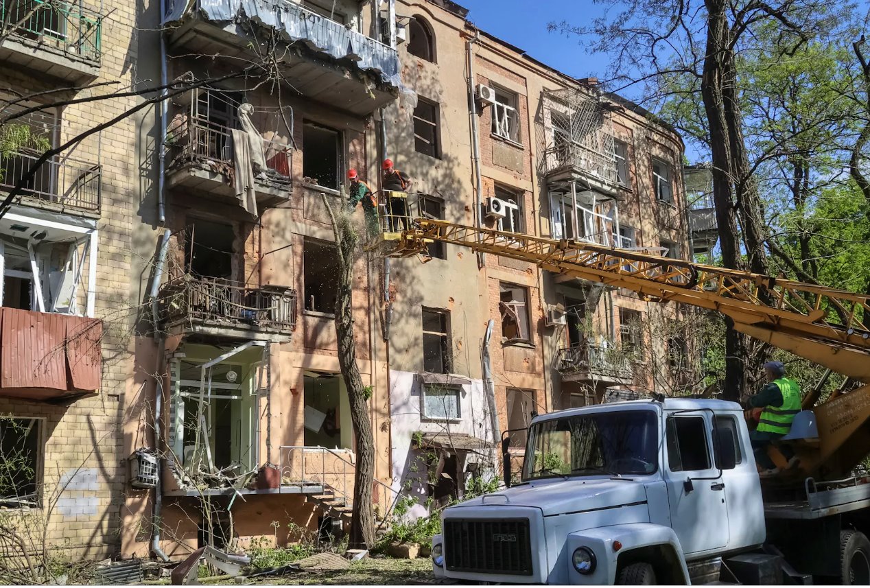 2024年5月5日，烏克蘭哈爾科夫，社區工作人員在烏克蘭哈爾科夫一棟因俄羅斯空襲而受損的公寓樓附近的工地工作。