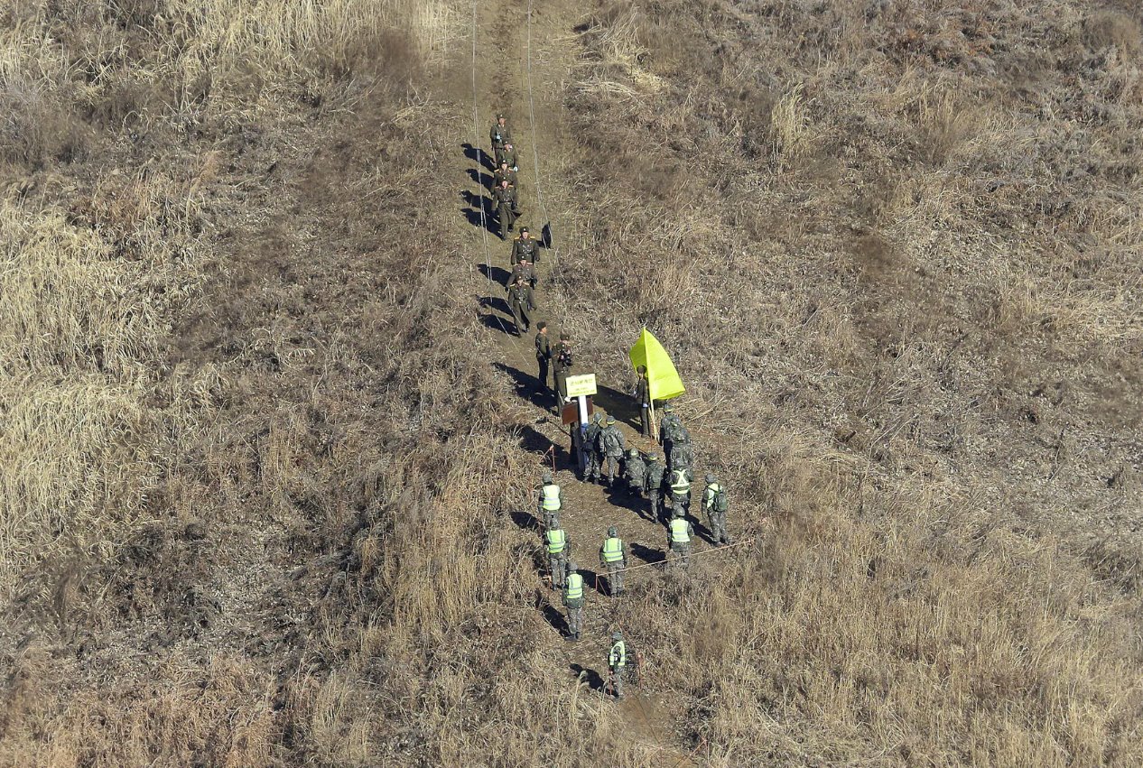 2018年12月12日，朝鮮軍隊士兵（上）越過非軍事區(DMZ)內的軍事分界線，檢查已拆除的韓國哨所，韓國軍隊士兵則在鐵原的朝韓邊界中部地區觀看。