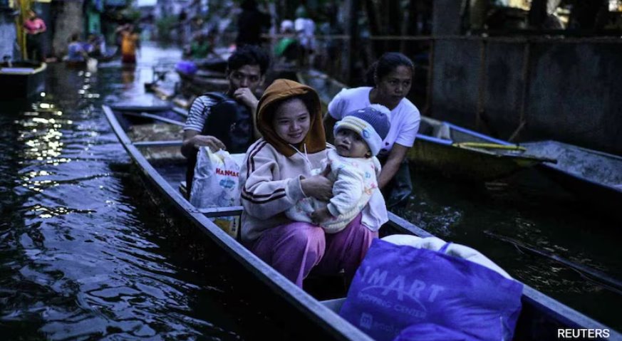 菲律賓熱帶風暴博羅依加劇降雨,民眾乘船過馬路